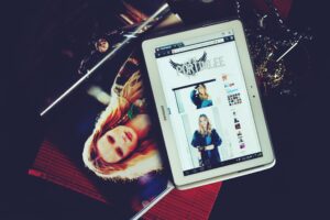 Stylish lifestyle photo showcasing a fashion magazine and tablet with a fashion website, ideal for e-commerce themes.